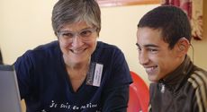 Christine, president of AuditionSolidarité adjusts hearing aids